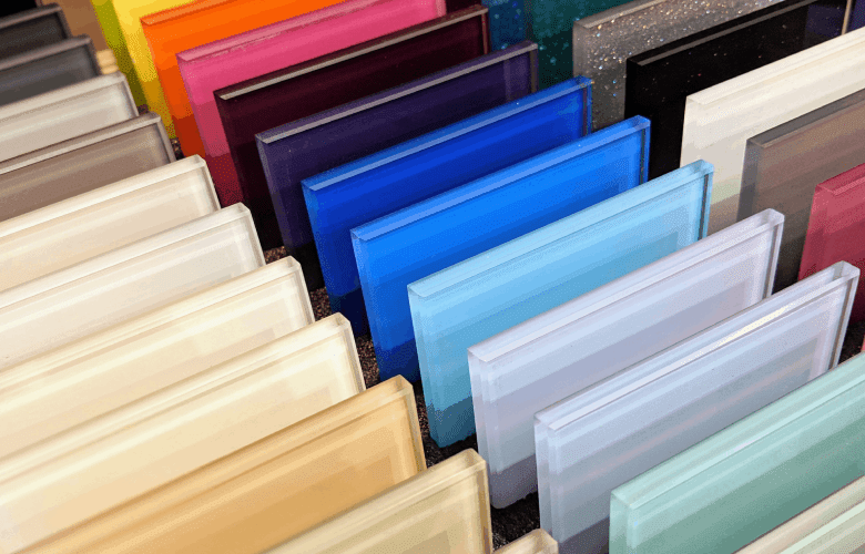 Veel staaltjes van gekleurd glas in verschillende kleuren op een rij.